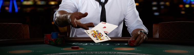 a dealers' hands throwing cards on the blackjack table
